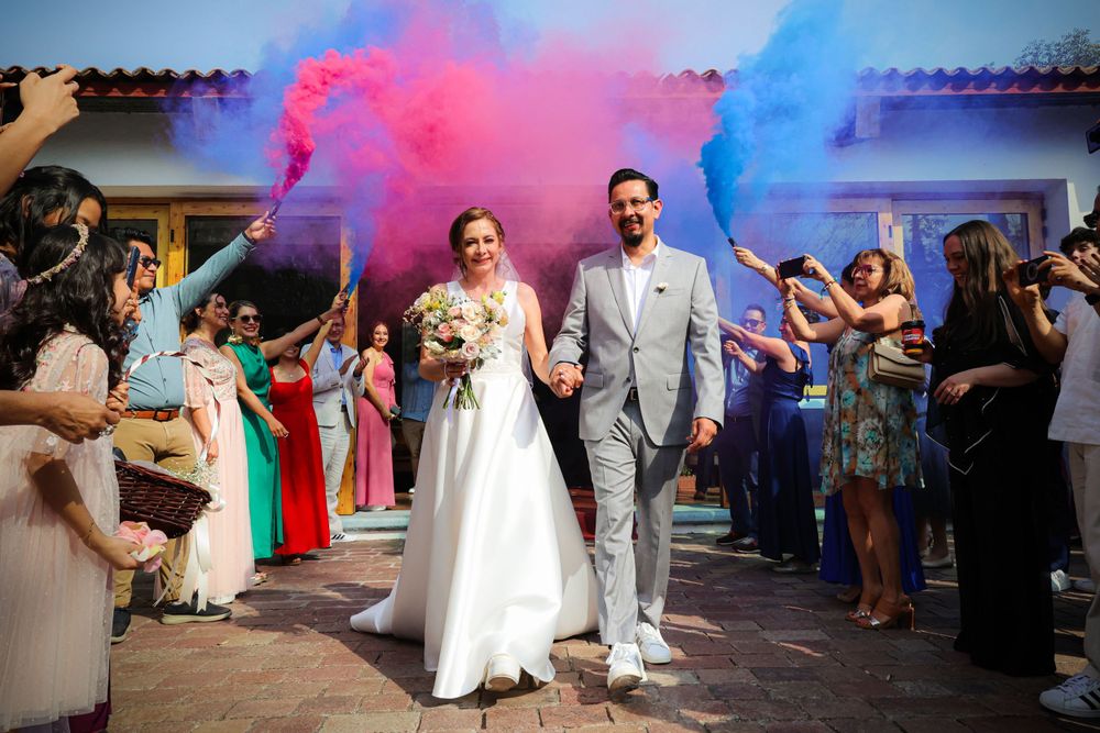 Wedding celebration with colorful smoke effects creating a vibrant atmosphere on the dance floor.