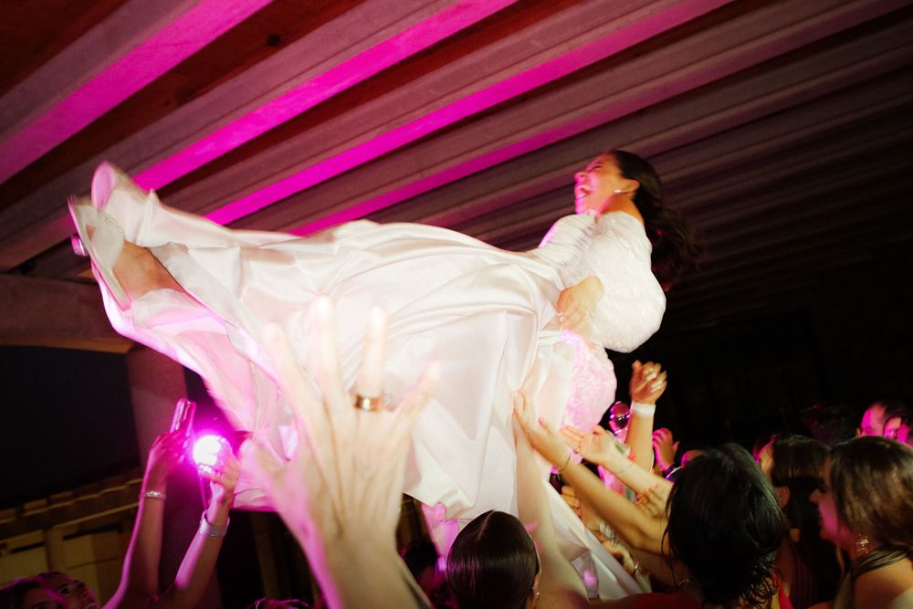 Wedding reception dance floor illuminated with vibrant pink lighting.