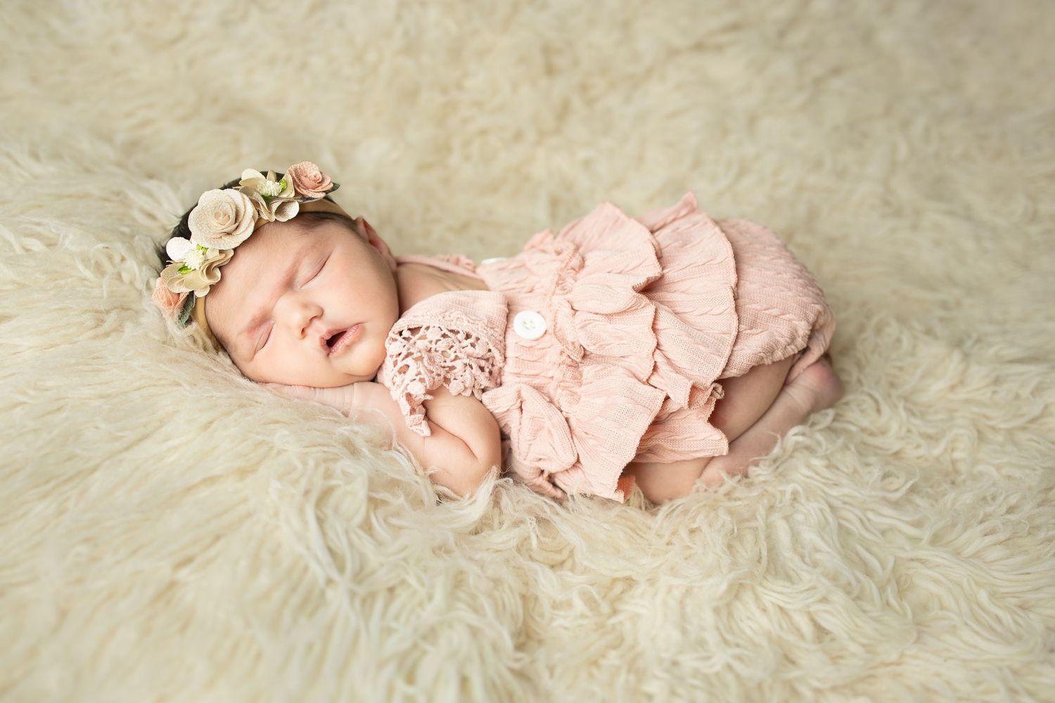 Artistic newborn photography series showing baby wrapped in blue fabric against dark background.