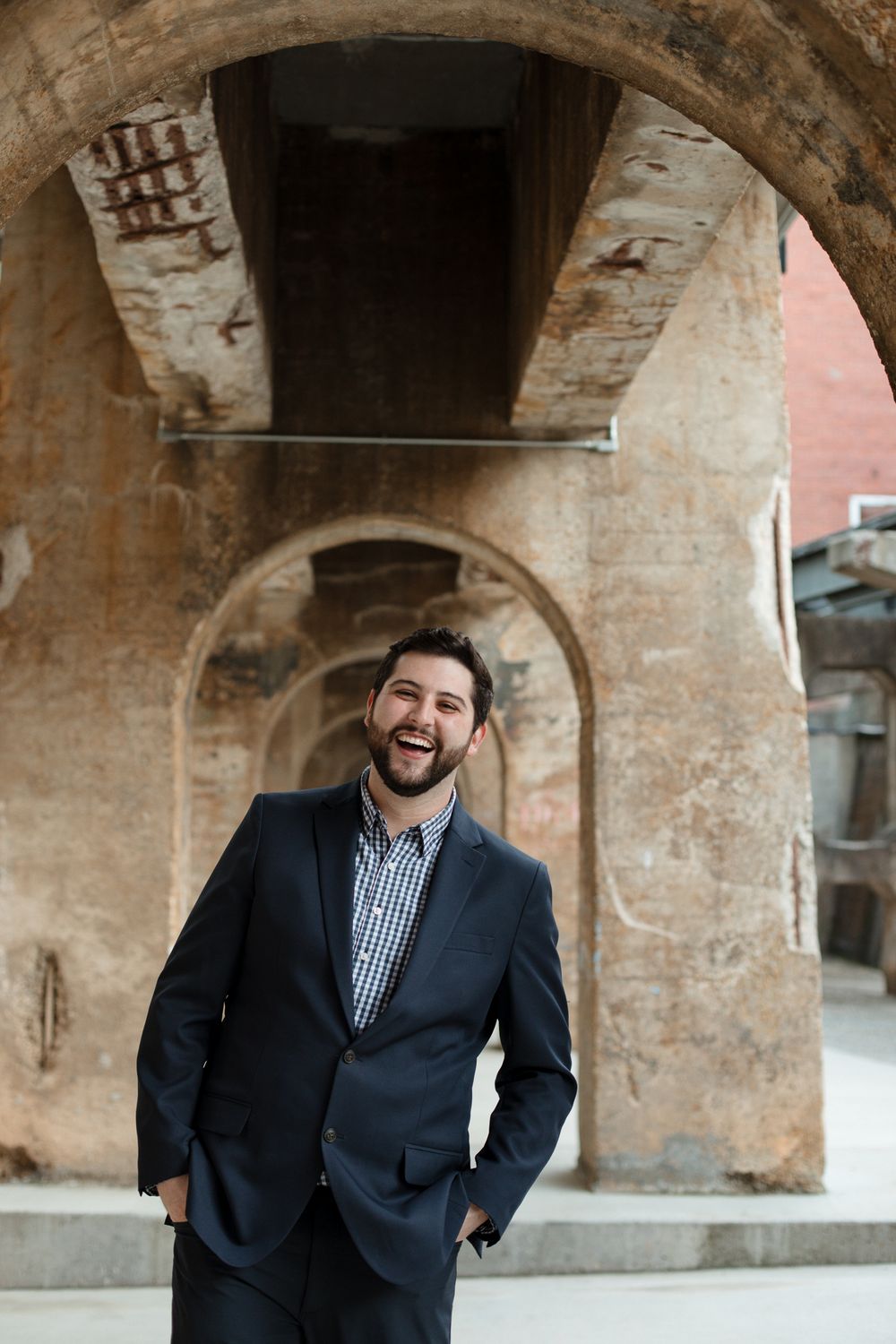Professional portrait session under historic brick archways in an urban setting.