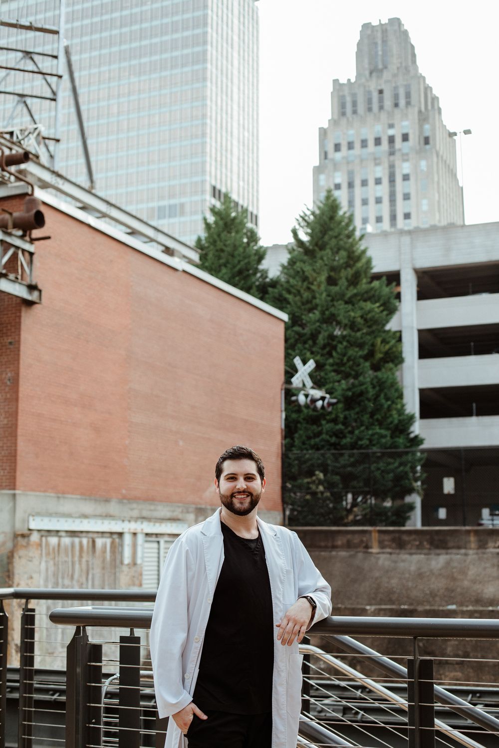 Professional headshots taken against an urban backdrop with glass buildings and brick architecture.