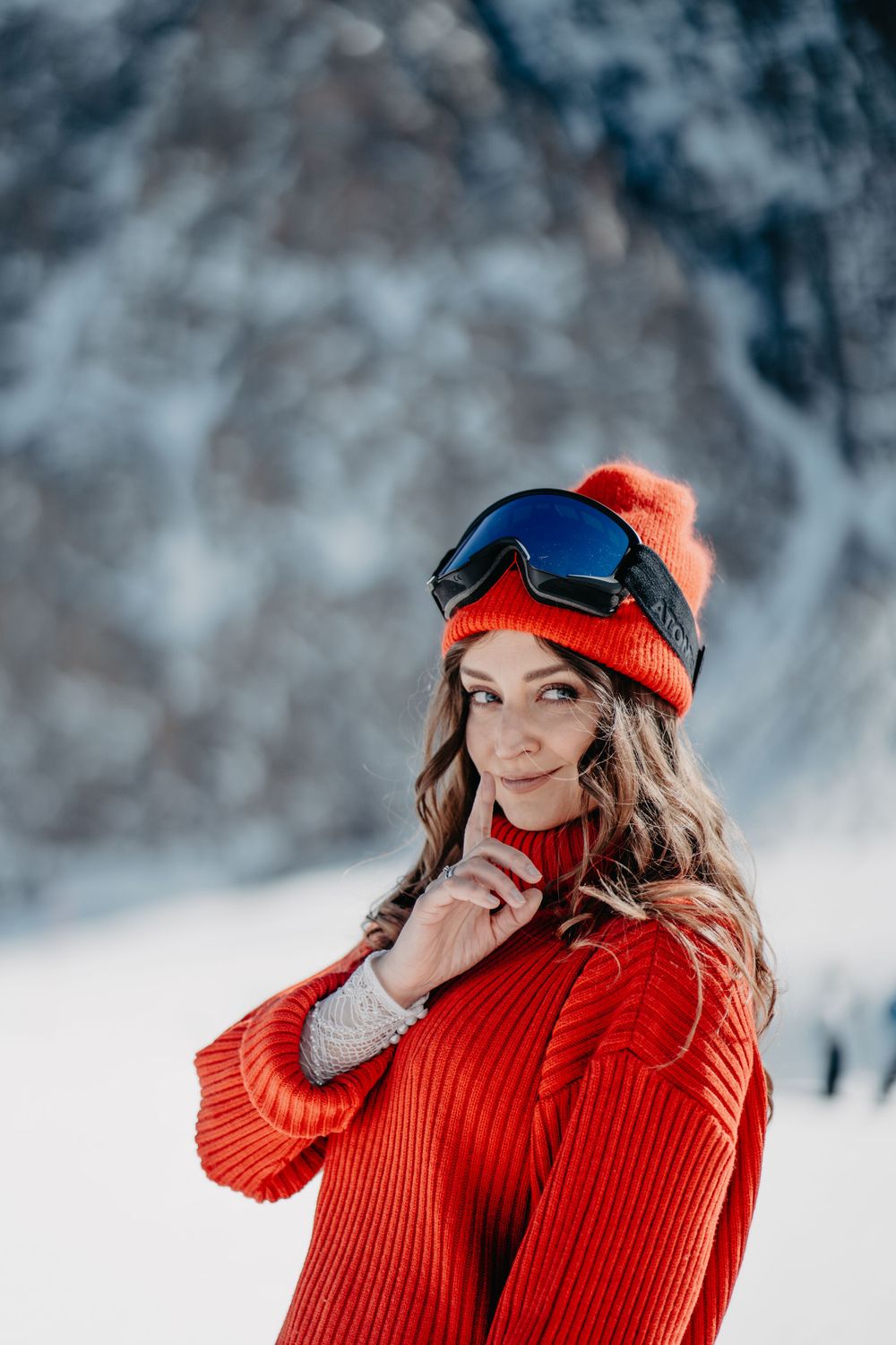 Bride wearing a red sweater, hat, and snowboarding goggles