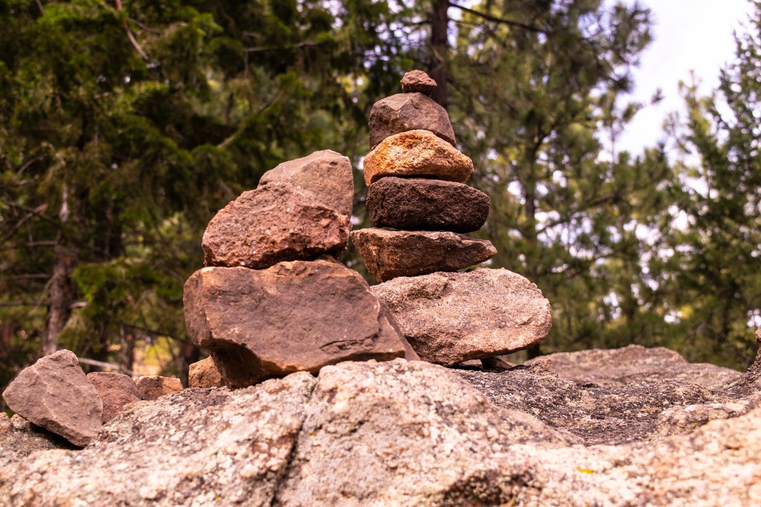 Balanced rock cairn formation on a natural stone outcropping in nature.