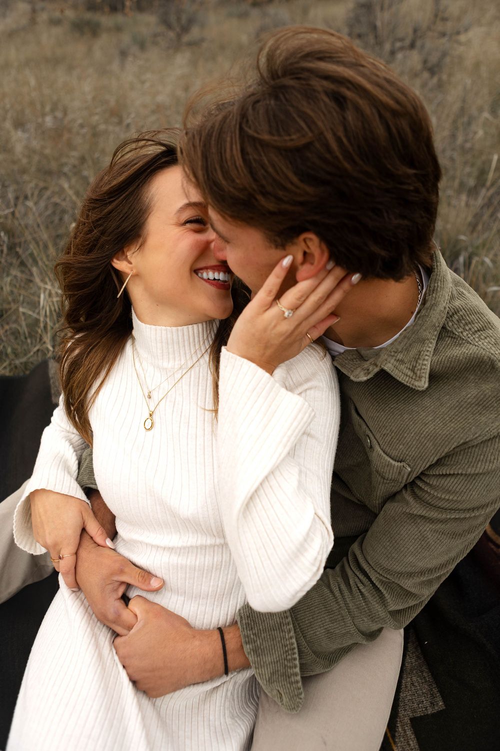 A romantic sequence showing a couple in white and olive clothing embracing against a stone wall.