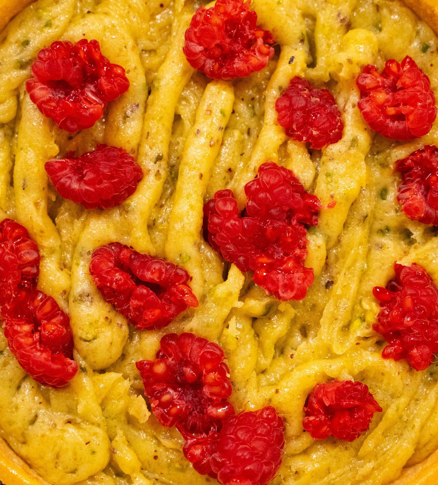 Creamy pasta dish topped with bright red roasted tomatoes in a close-up view.