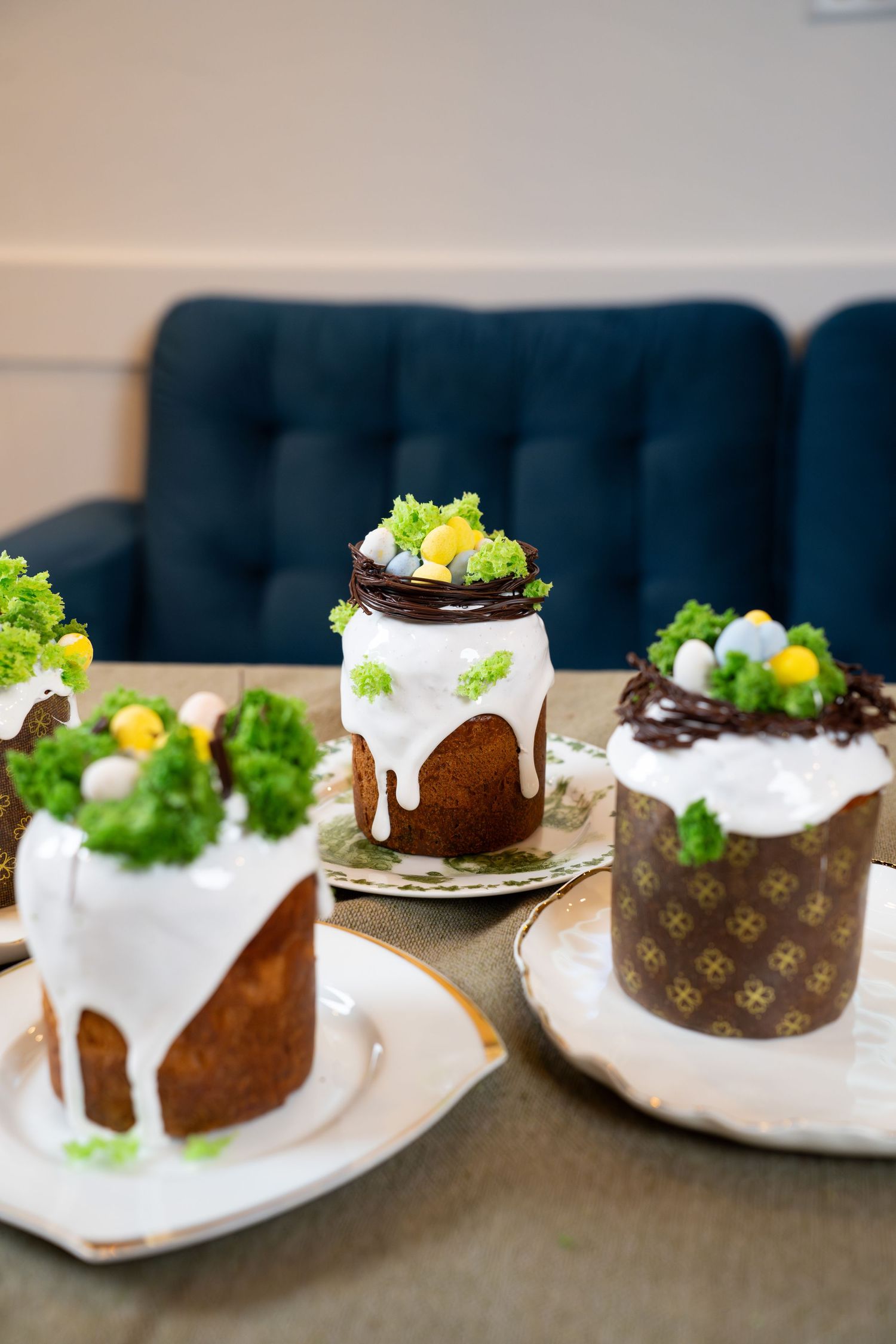 Chocolate cakes with white frosting and green garnishes displayed on plates with elegant decorative details.