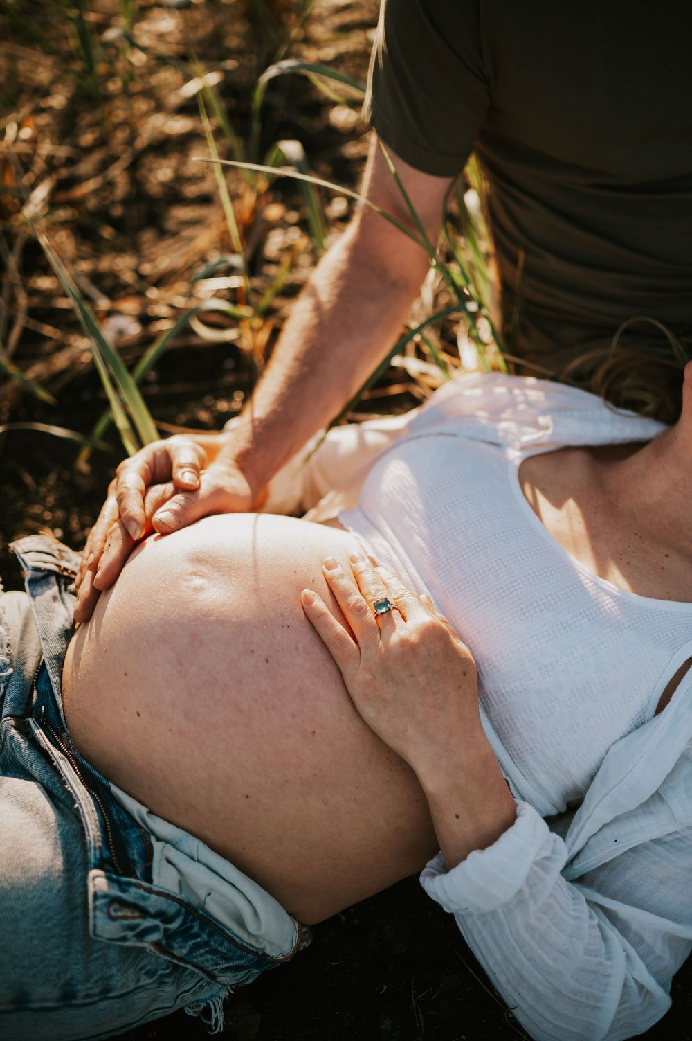 Sunset maternity photoshoot of pregnant belly sitting in Comox Valley beach grass. Photography by Photographer Soulfull Photographs