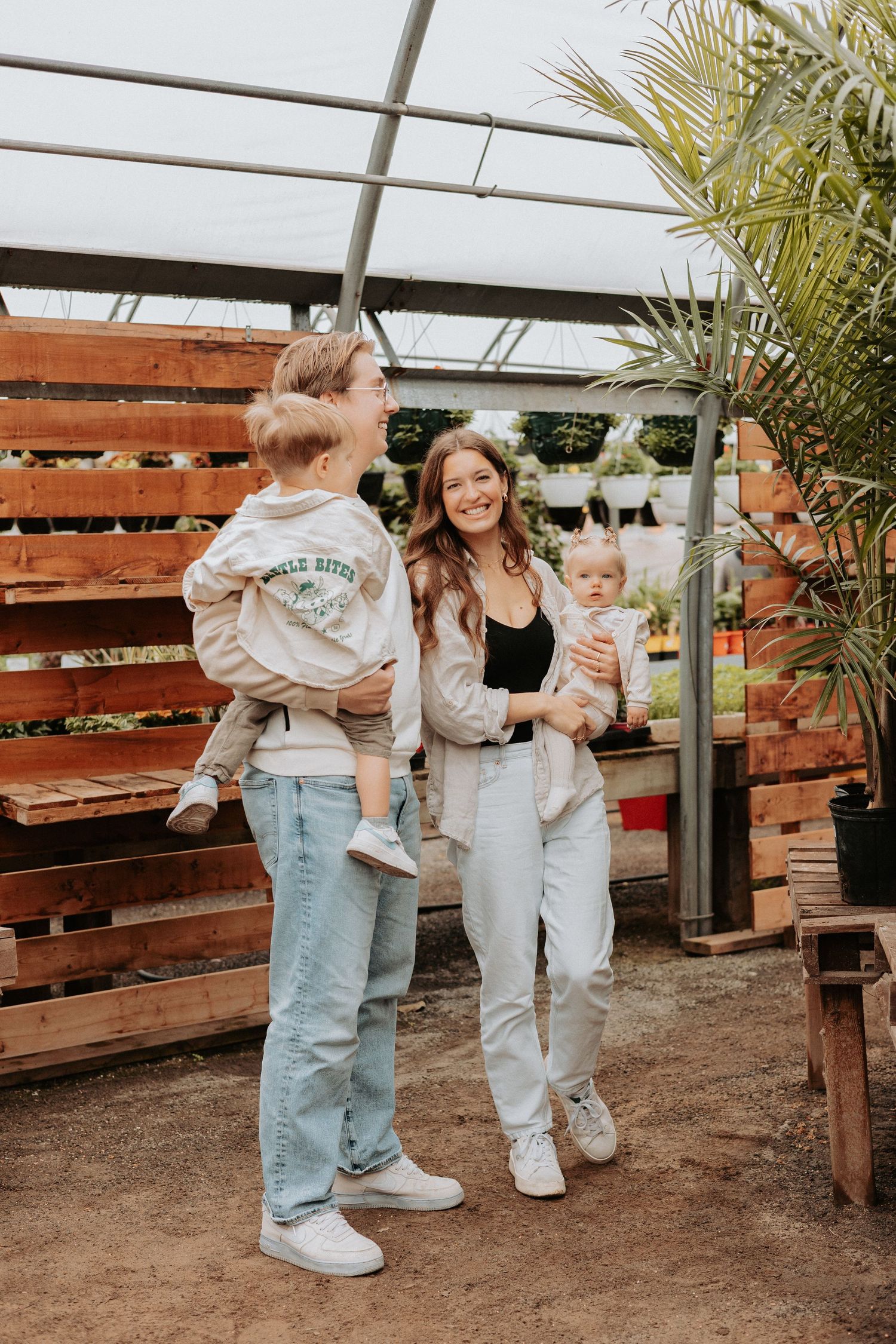 Family candid moments sequence in rustic garden setting against wooden fence backdrop as kids play together.