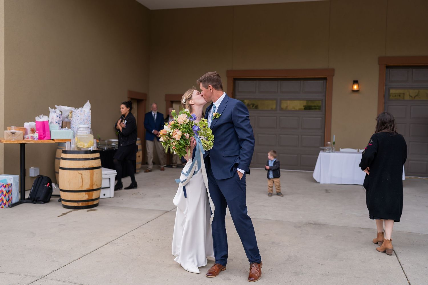 A celebratory moment outside a venue with wine barrels and party decorations.
