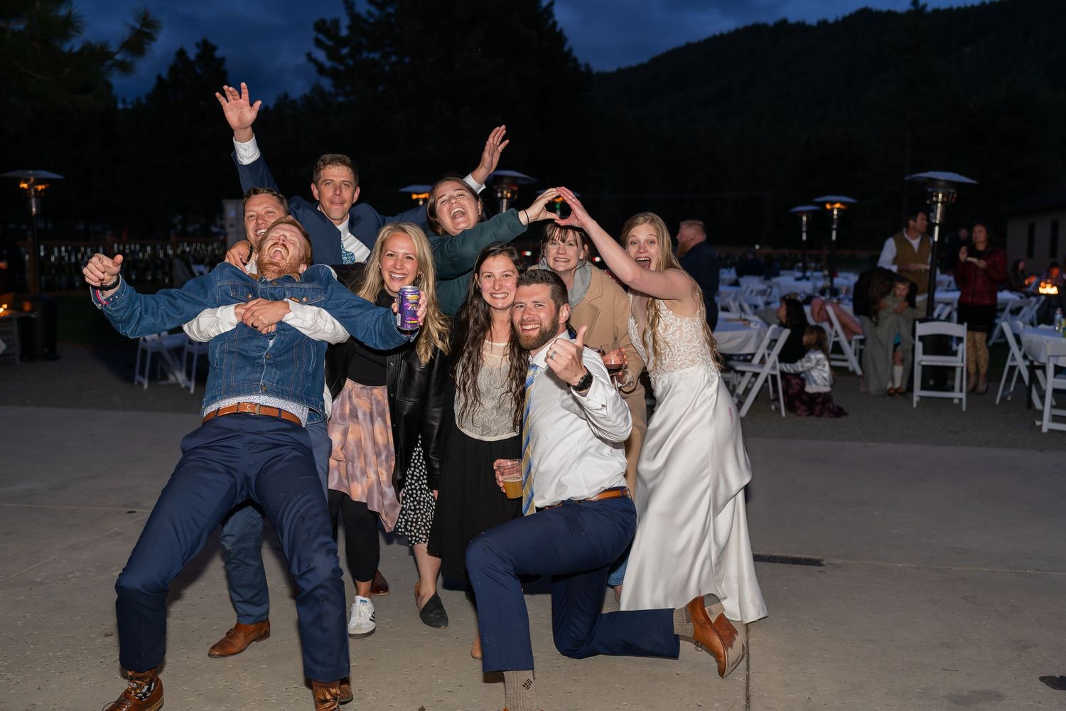 Wedding reception guests dancing and celebrating outdoors at dusk.