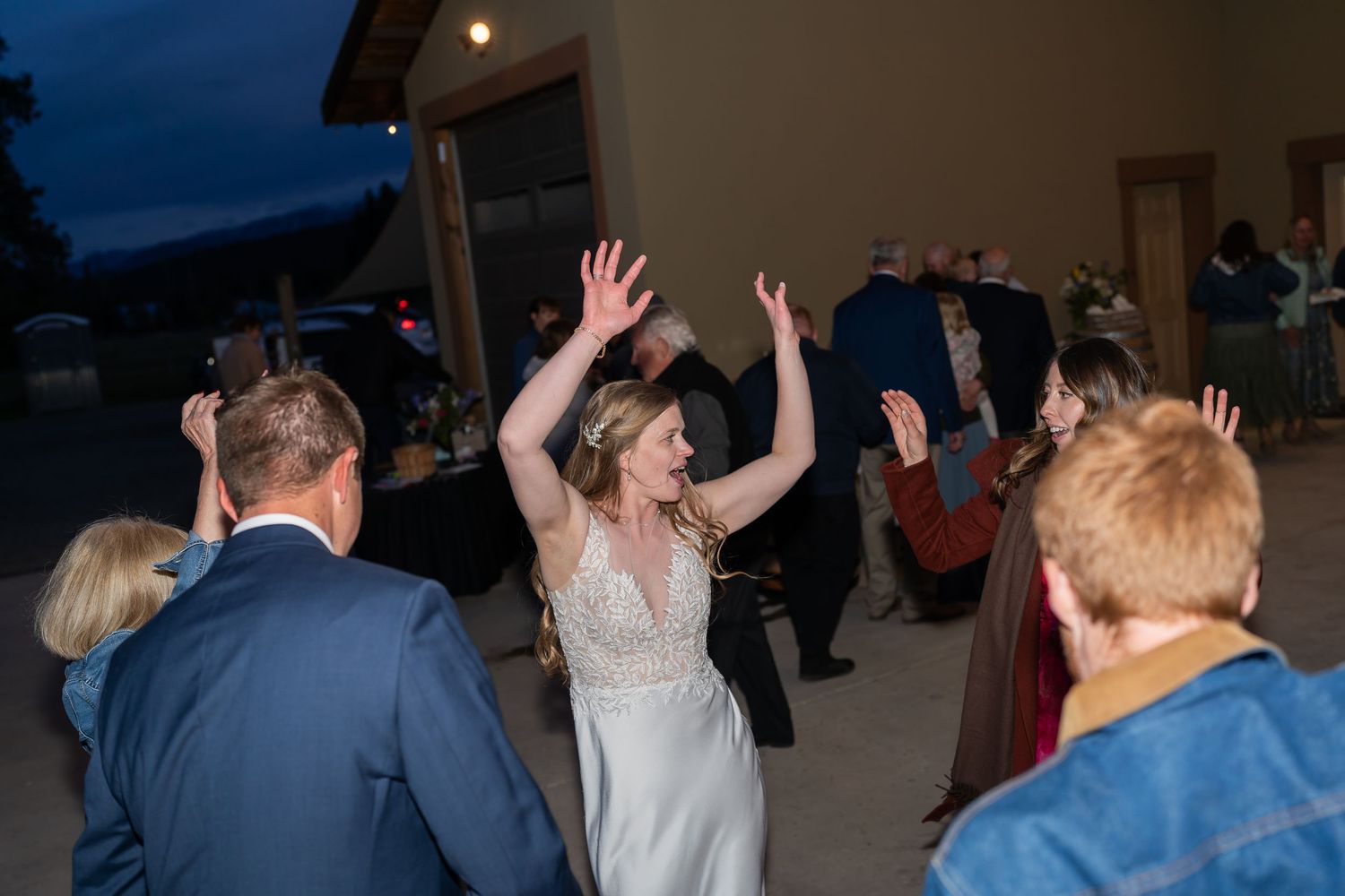 Wedding guests dancing and celebrating at a reception during a joyful evening celebration.