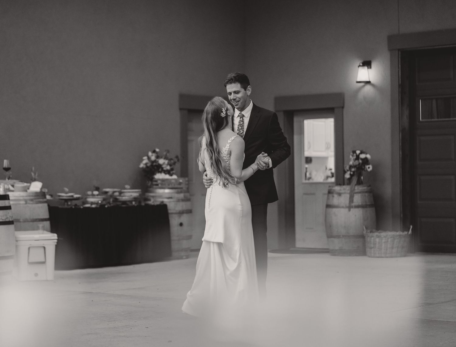Couple sharing an intimate slow dance in an elegant reception hall.