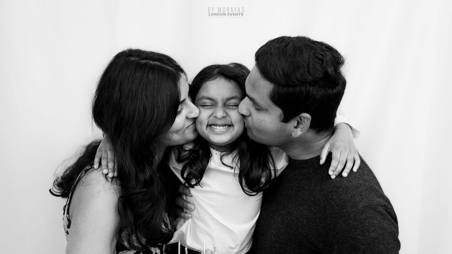 Black and white portrait of three people sharing an intimate moment.