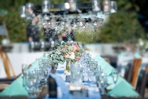 Elegant table setting with crystal glassware and floral centerpieces in soft focus.