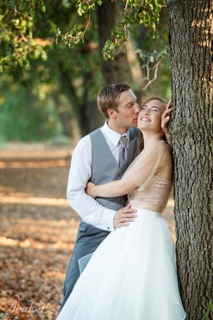 Romantic portrait against a tree trunk in soft autumn lighting.