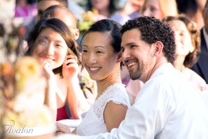 Wedding guests smile and celebrate during an outdoor reception.