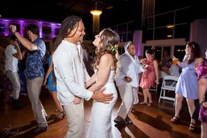 Wedding couple shares a romantic dance surrounded by guests at evening reception.