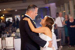 Wedding couple shares their first dance in an elegantly lit reception venue.