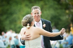 Dancing couple celebrating during outdoor wedding reception.