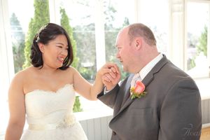 A couple shares a joyful moment during their wedding ceremony in a bright indoor venue.