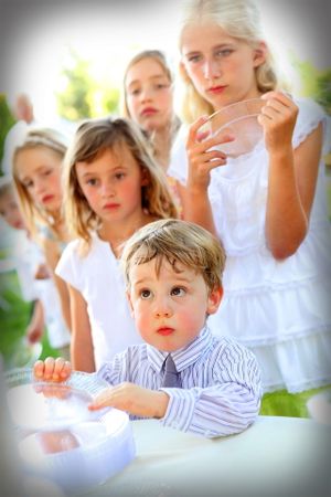 Adorable young children lined up waiting for wedding cake.