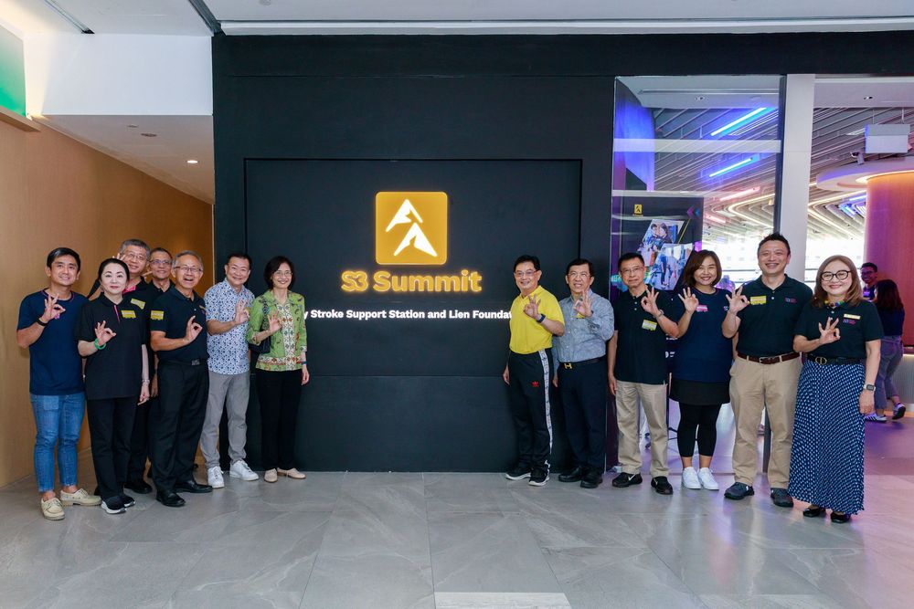 Group of people posing together in front of a 33 Summit stroke support station and live founder sign.