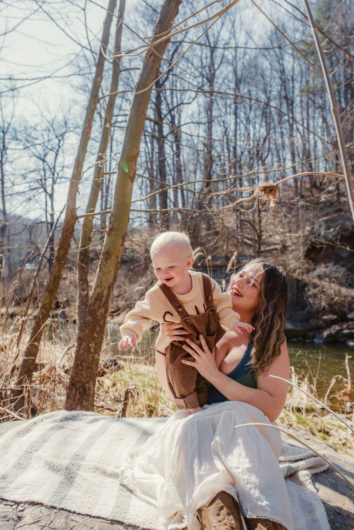 Candid family moments captured in sunlit forest setting.