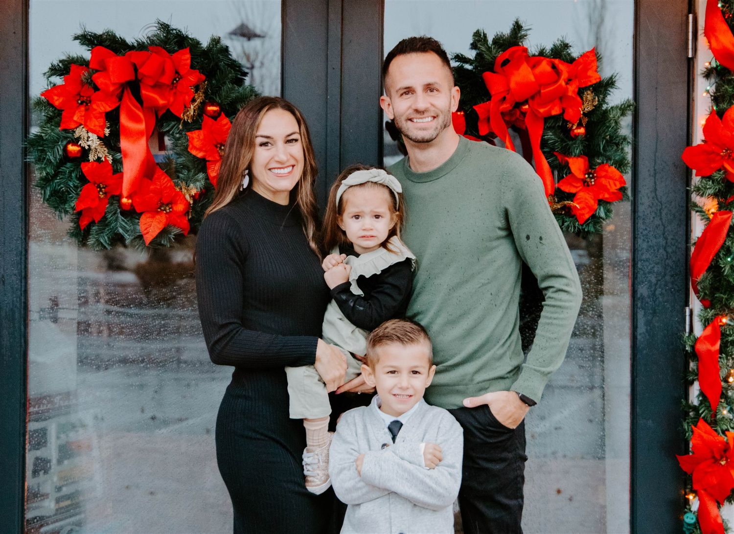 A holiday portrait with red poinsettia wreaths decorating the background.