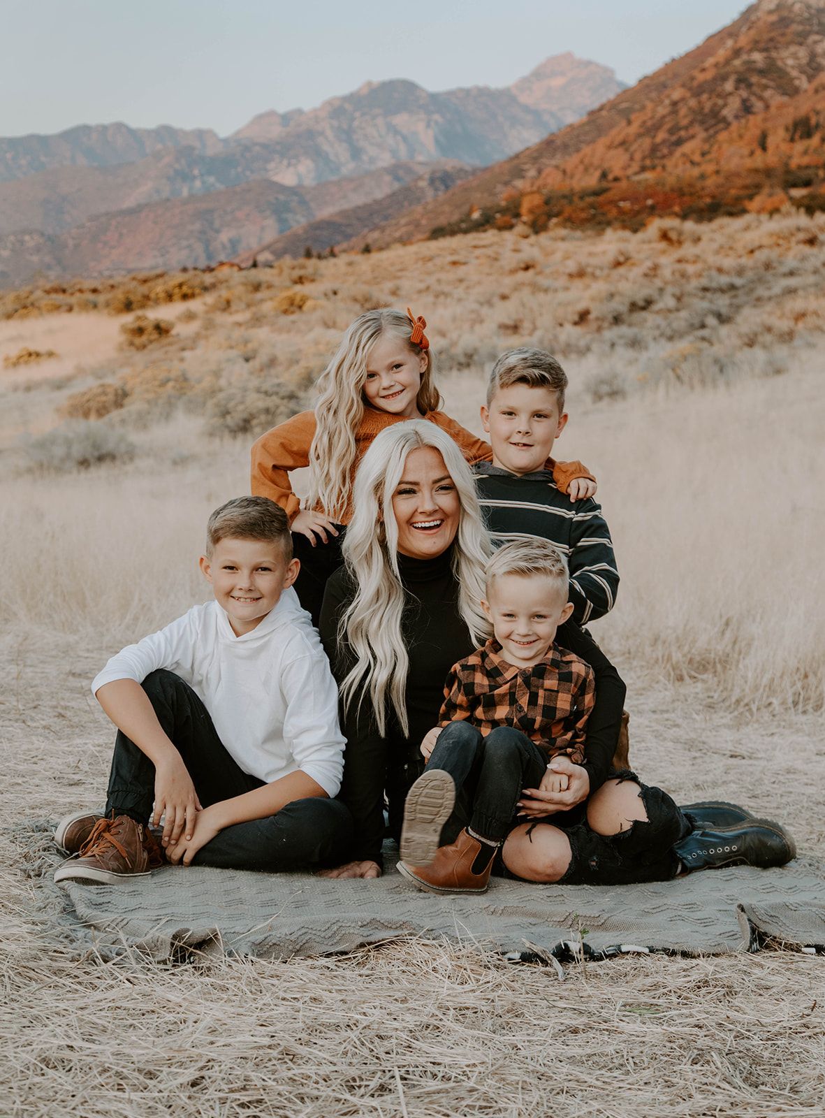 A group portrait against a desert mountain backdrop during golden hour.