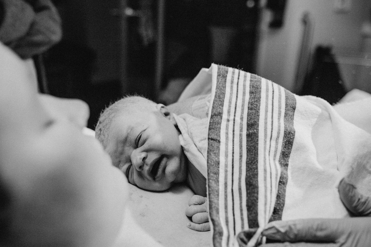 Birth photography by Fully Known Services.  Newborn baby laying on mother's chest right after birth.