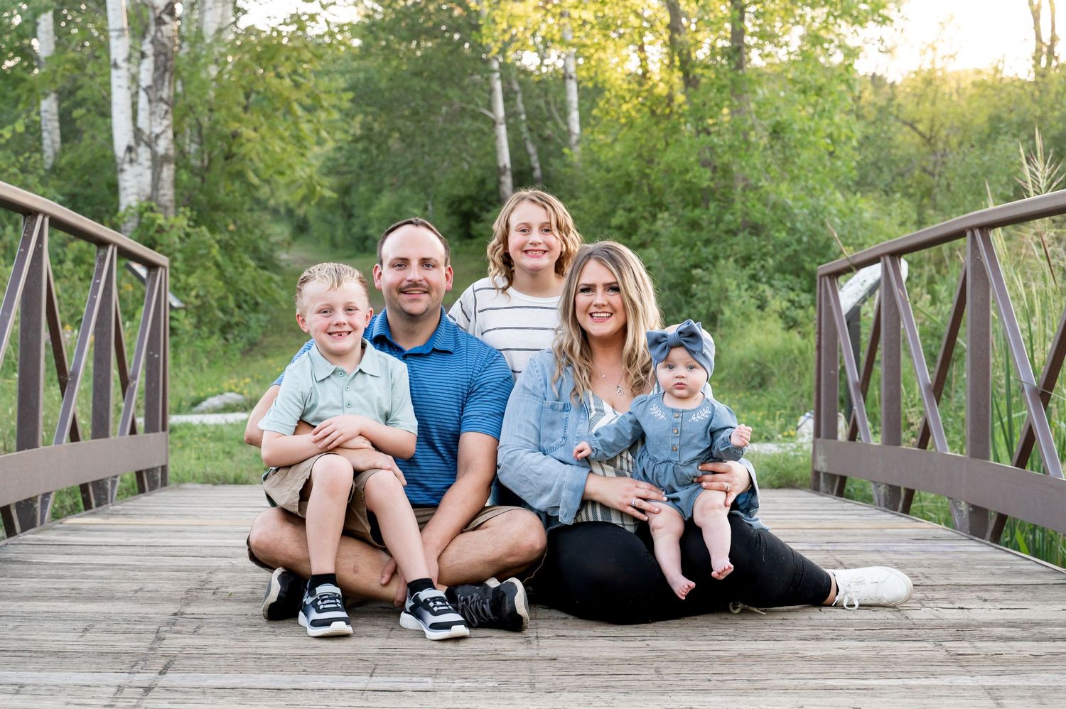 happy family sitting on bridge