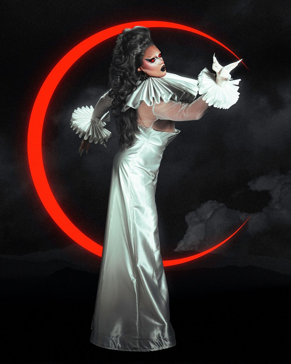 Person in flowing white satin dress creates dynamic light trails against dark background with glowing red arc.
