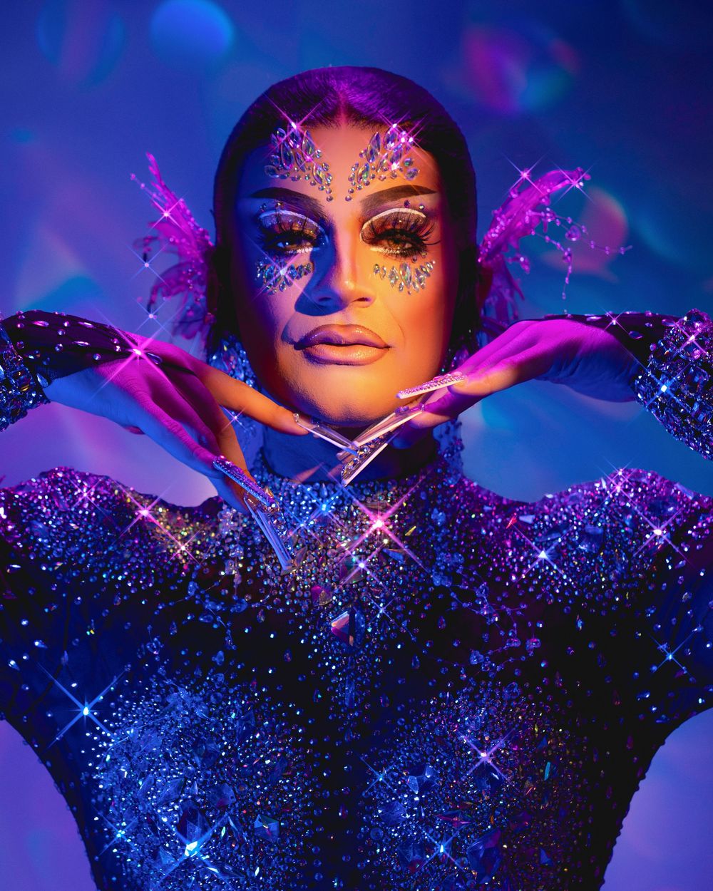 Abstract glittery portrait against dark blue background with sparkles and shimmering effects creating a magical atmosphere.