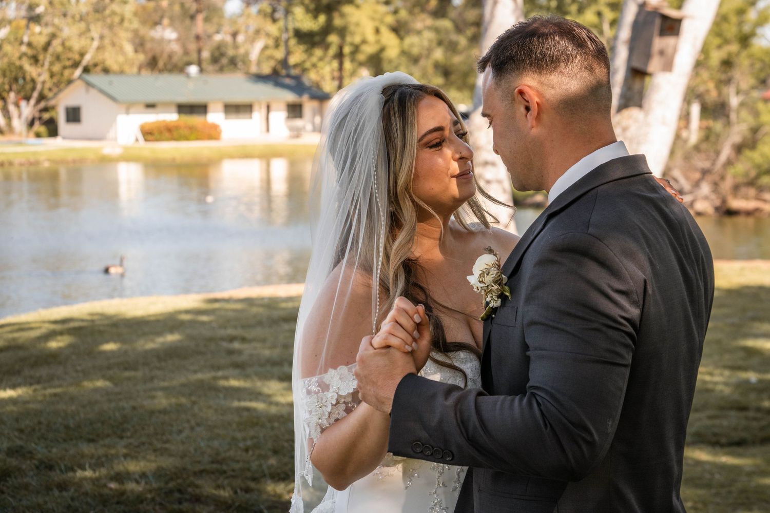 A romantic wedding portrait by a lake during golden hour.