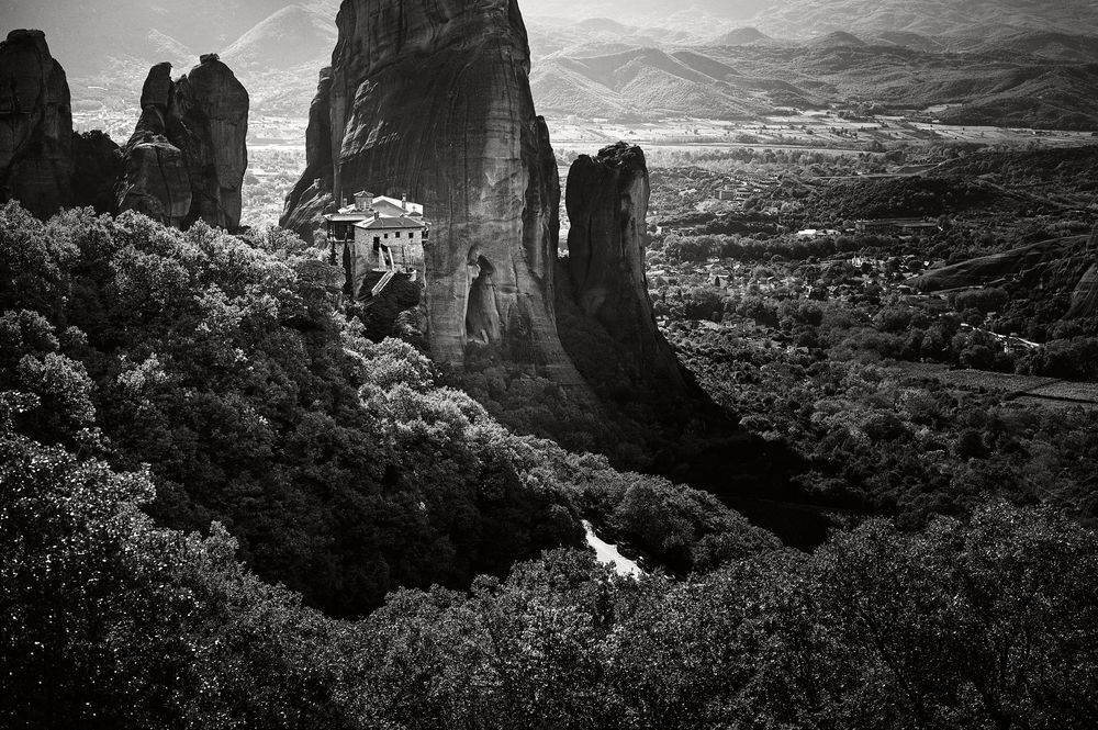 Dramatic black and white panoramic view of rugged mountain peaks and cliffs in a mountainous landscape.