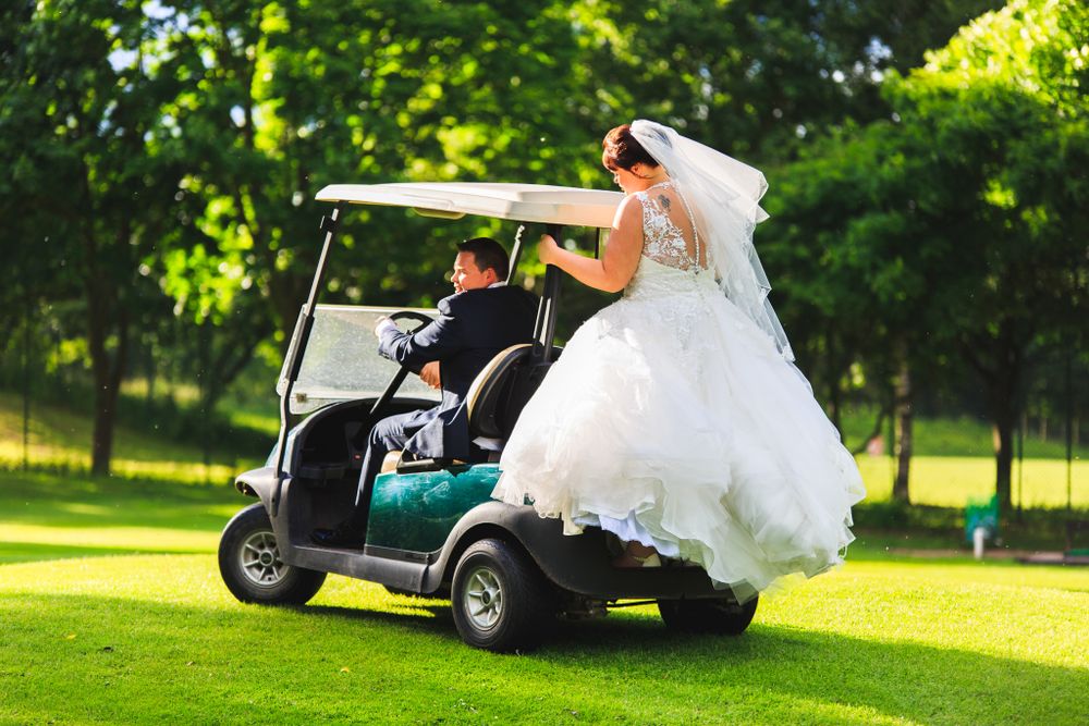 Hilarity as the Bride and groom play on golf scooters Lea Marston Hotel, in the grounds