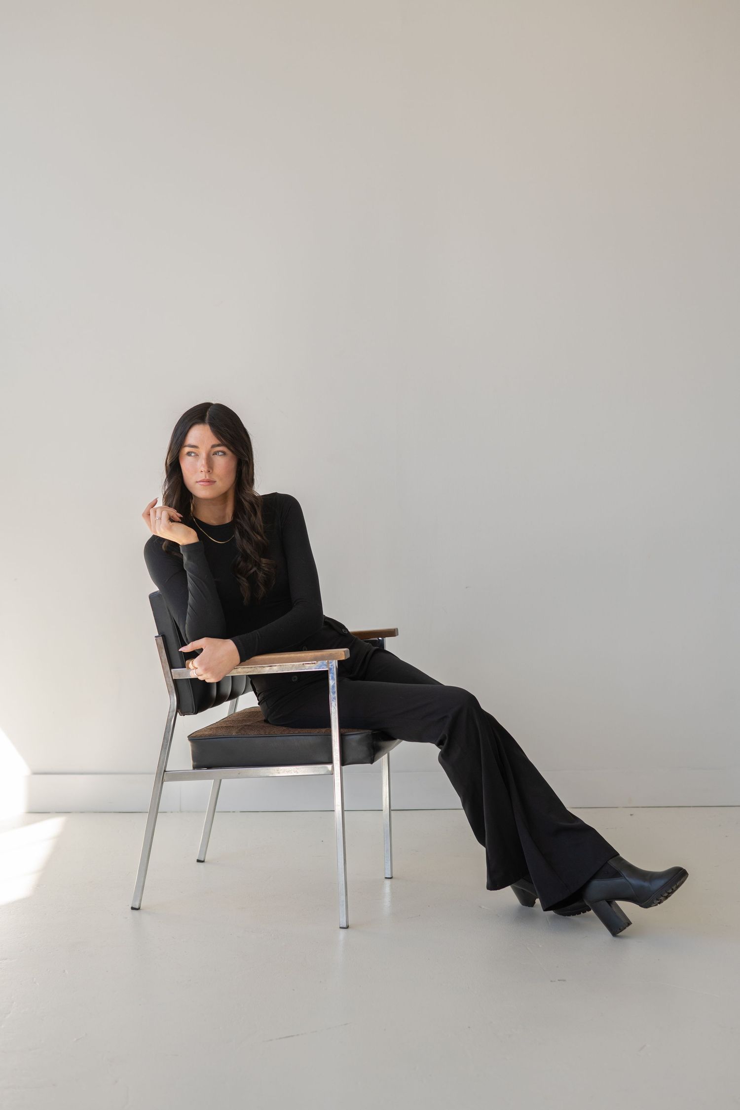 A series of artistic poses on a white chair against a minimalist white backdrop showing different reclining positions. Quinte West
