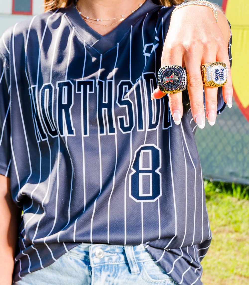 Person wearing Northside #8 pinstripe baseball jersey displaying a large championship ring on their finger.