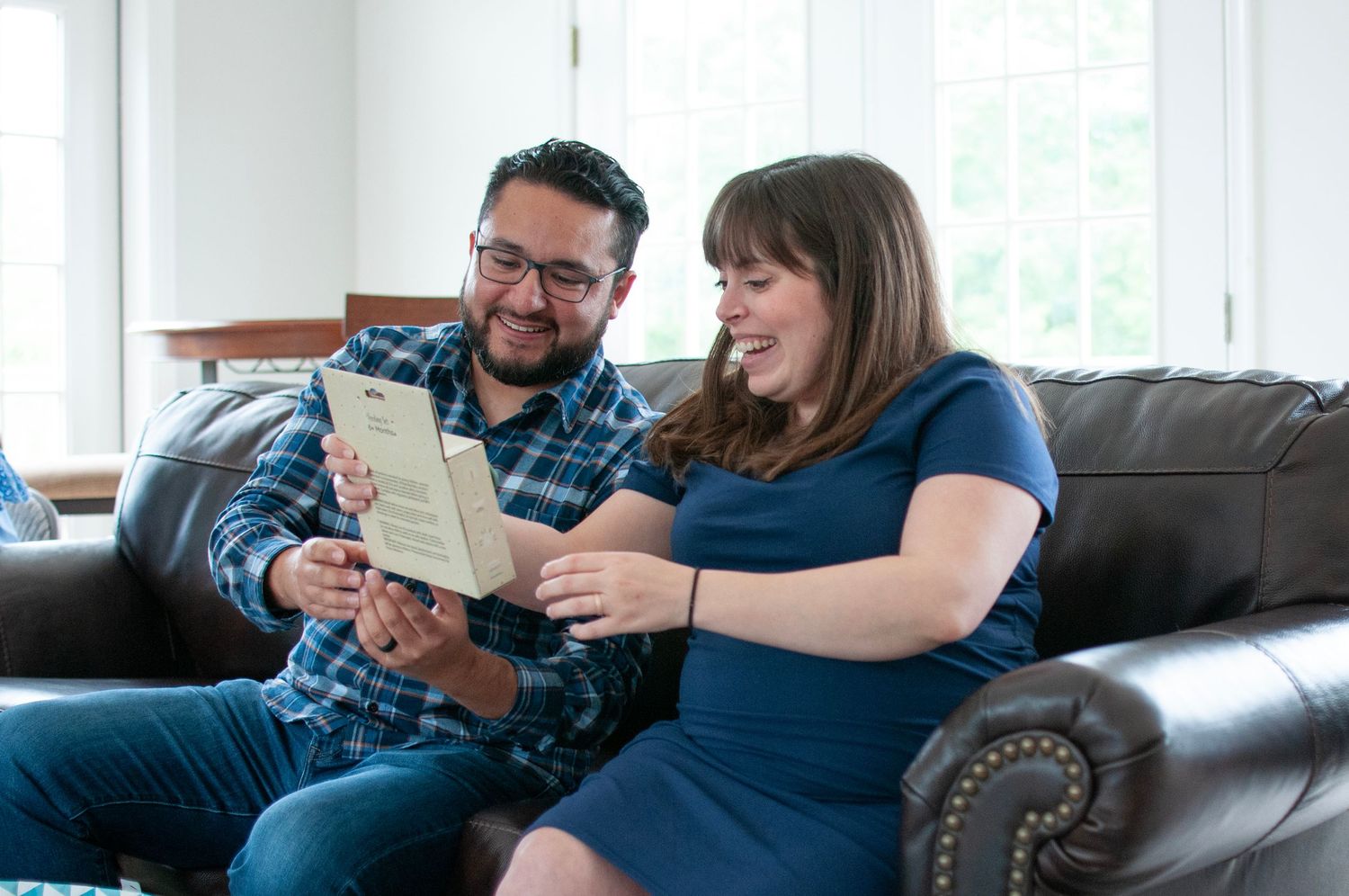 Couple reading card and opening gifts at baby shower