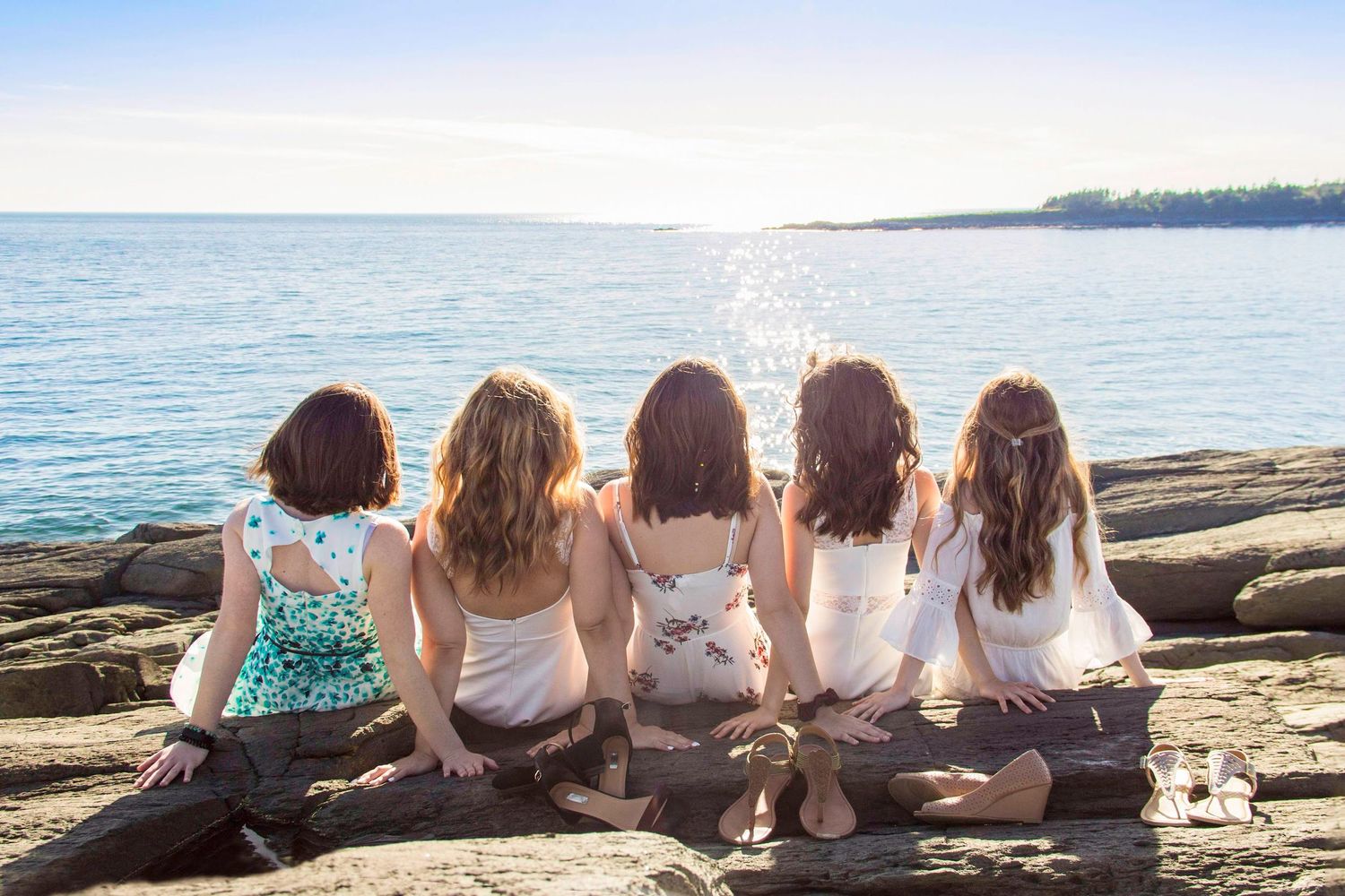 Group of girls sitting together enjoying a scenic ocean view in Yarmouth, NS, by Daneesha Williams Photography