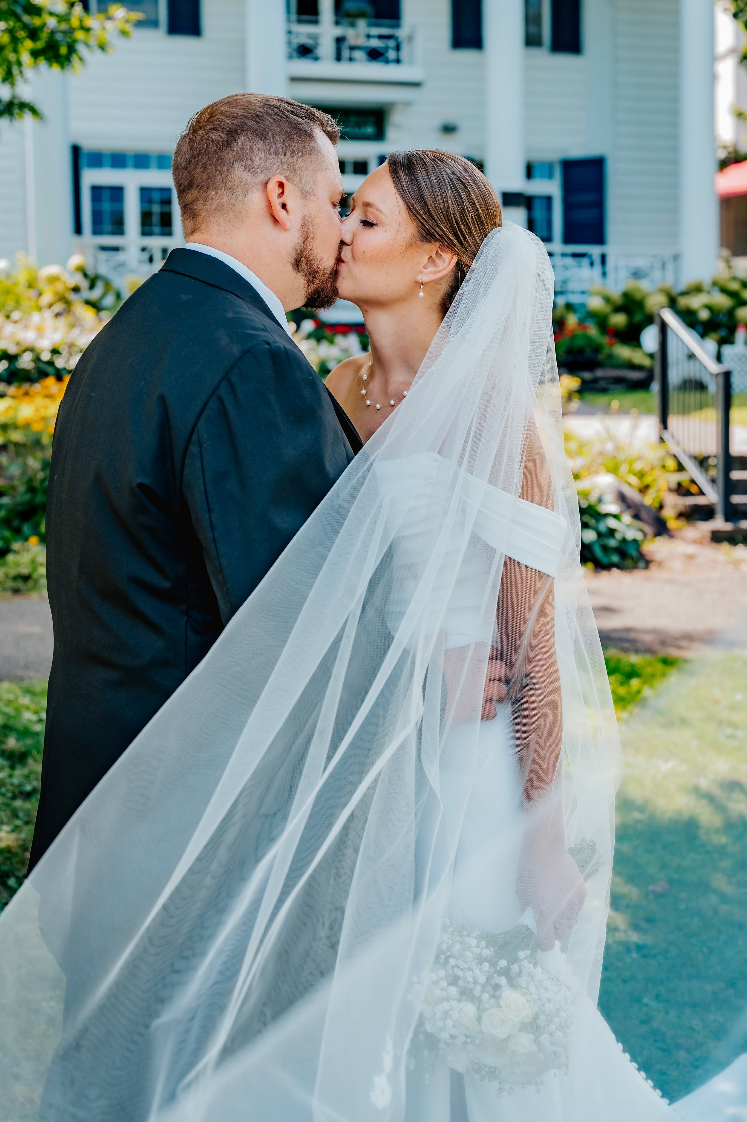 Elegant wedding portraits featuring flowing veil and intimate moments between newlyweds.