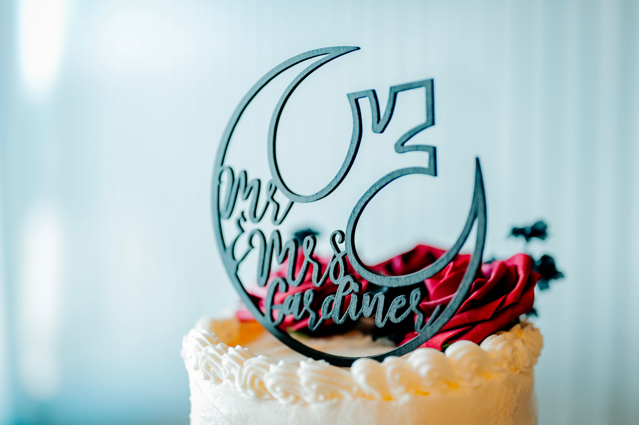 Close-up of wedding cake toppers against a light blue background.