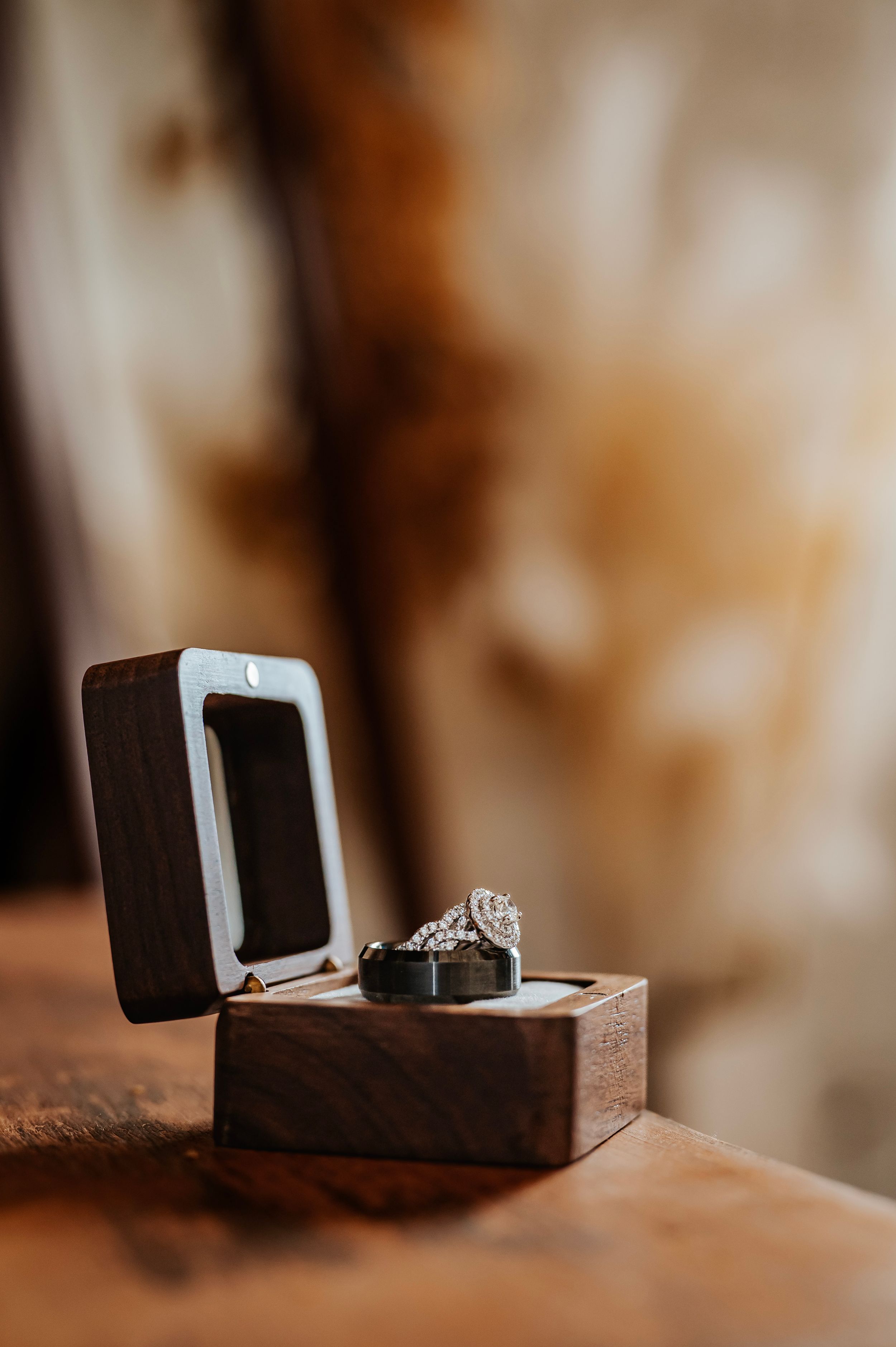 Close-up sequence of wooden ring box opening to reveal engagement ring.