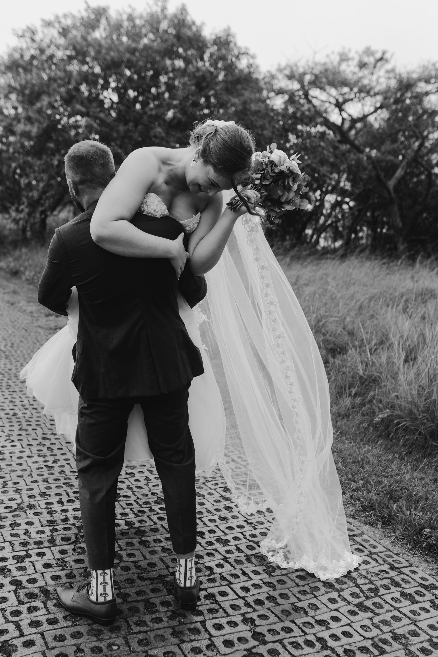 groom carrying bride on shoulder