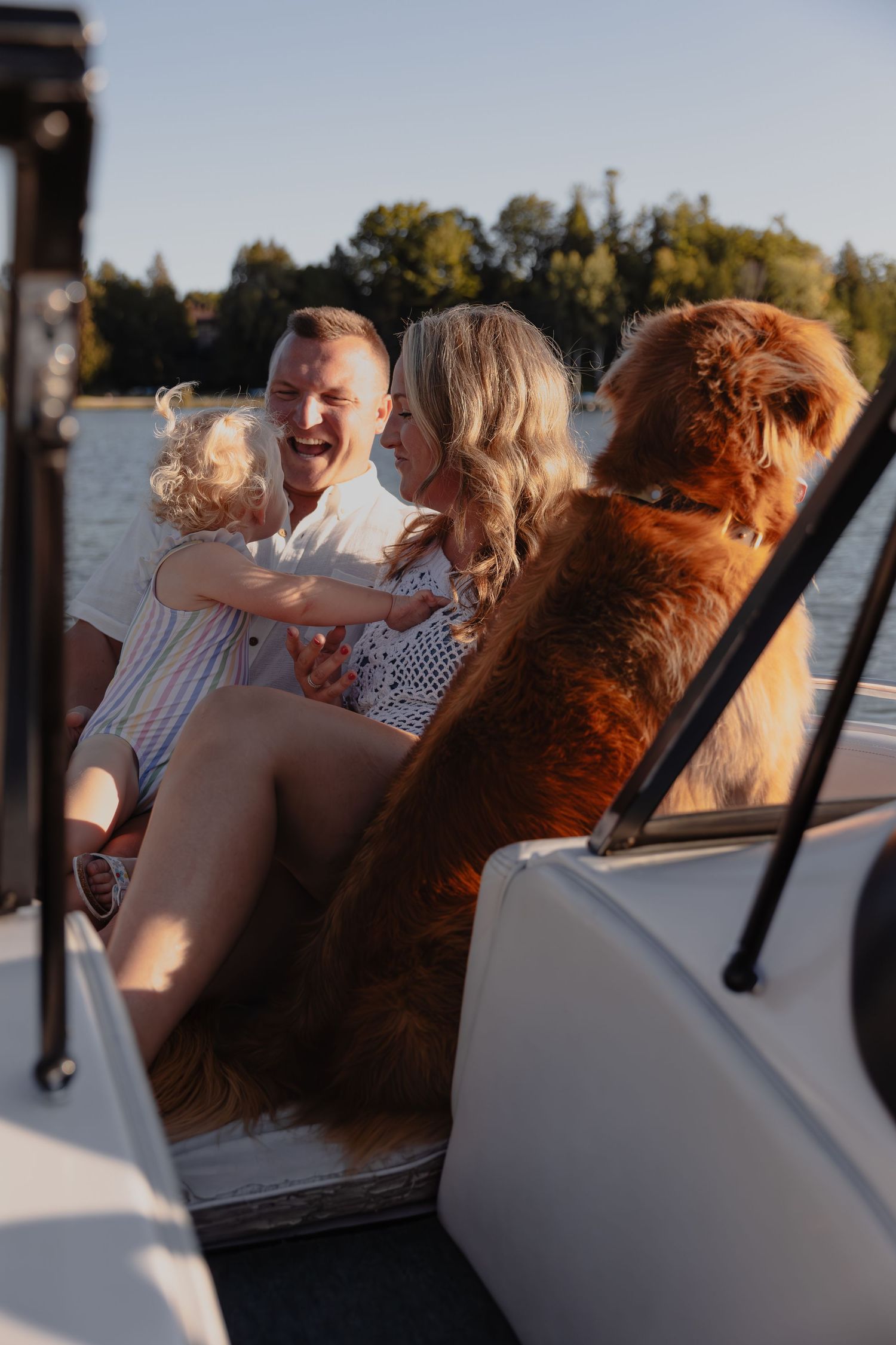 Family enjoying sunset boat ride with golden light illuminating their joyful expressions. Elkart Lake , WI with Essence Rose Photography.