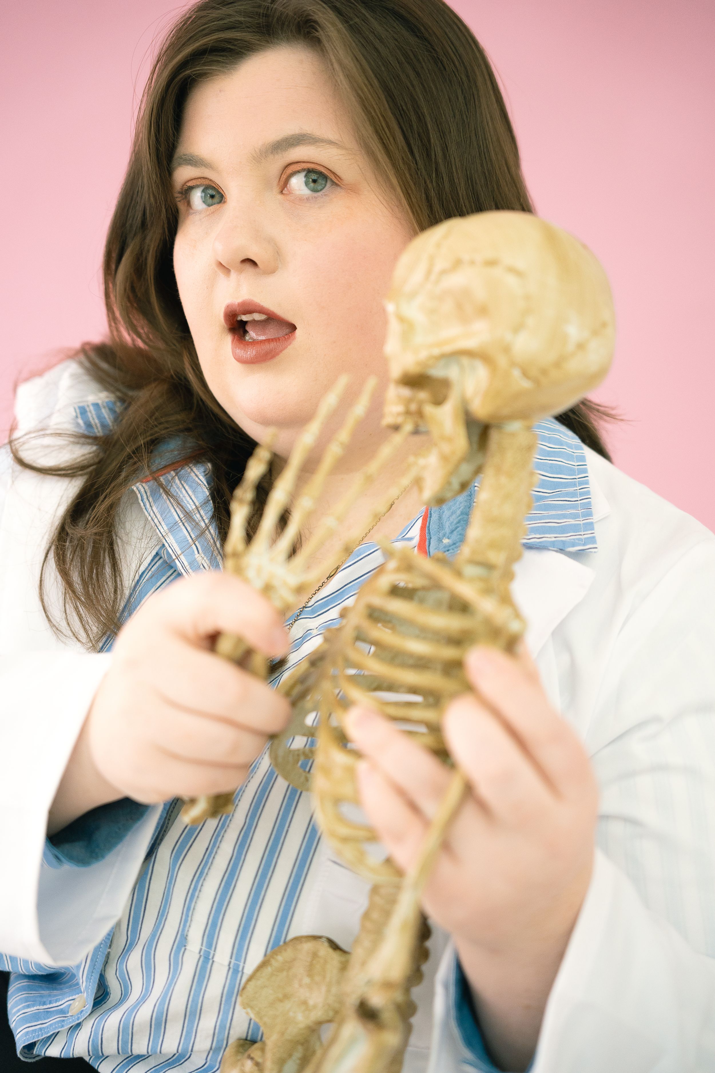A person in a striped shirt and white coat bites into a large sandwich in a series of progressive photos.