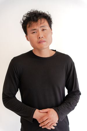 A person wearing a black long-sleeve shirt poses against a white background in three similar shots.