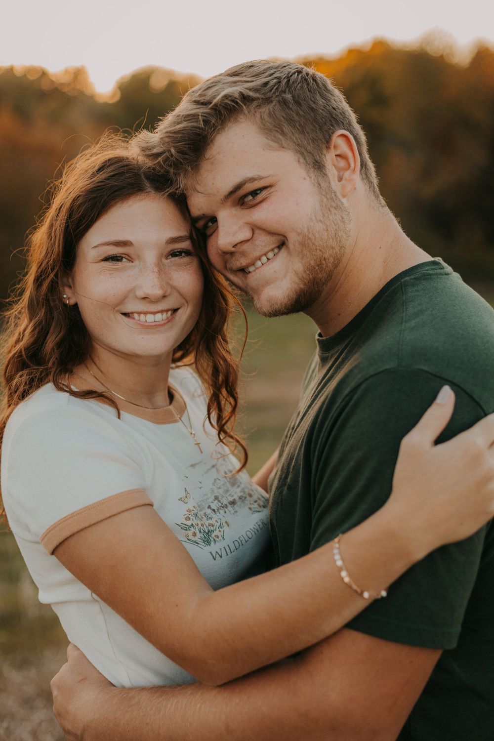 A couple shares a close embrace and bright smiles during their outdoor photo session.