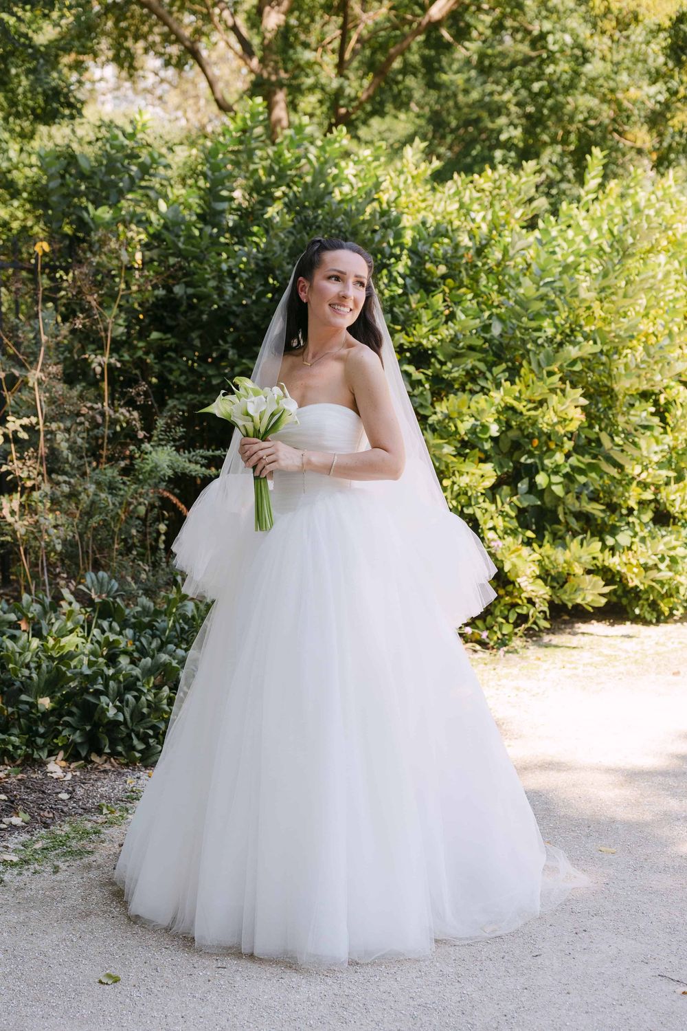 A series of outdoor bridal portraits showing a white ball gown wedding dress against lush greenery.