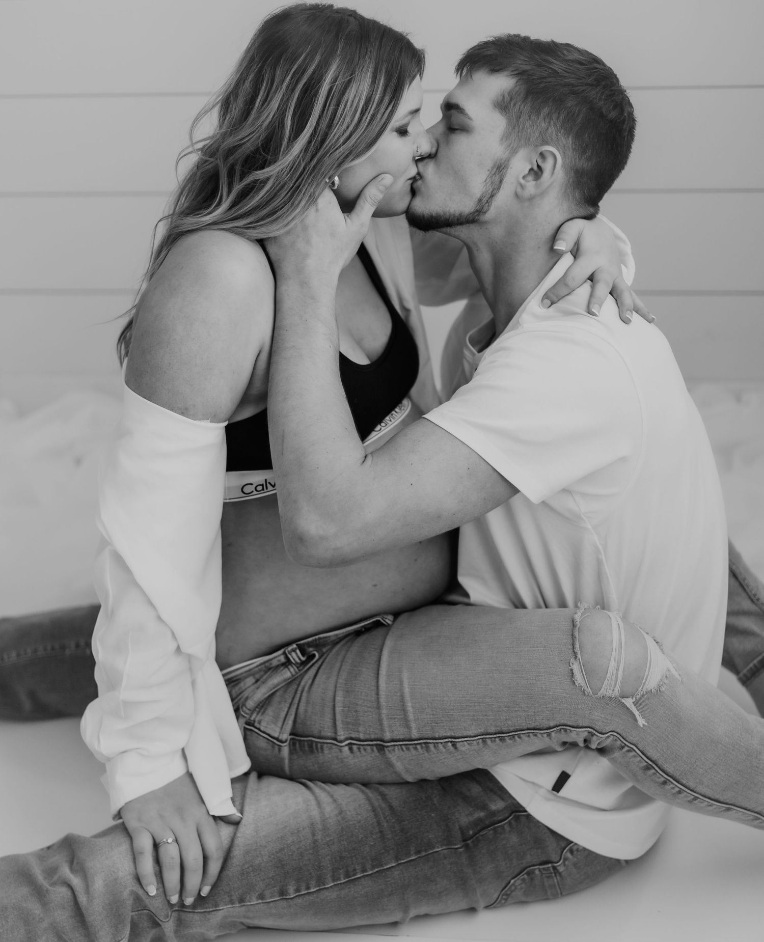 Intimate black and white photo of couple sharing romantic moment during maternity shoot.